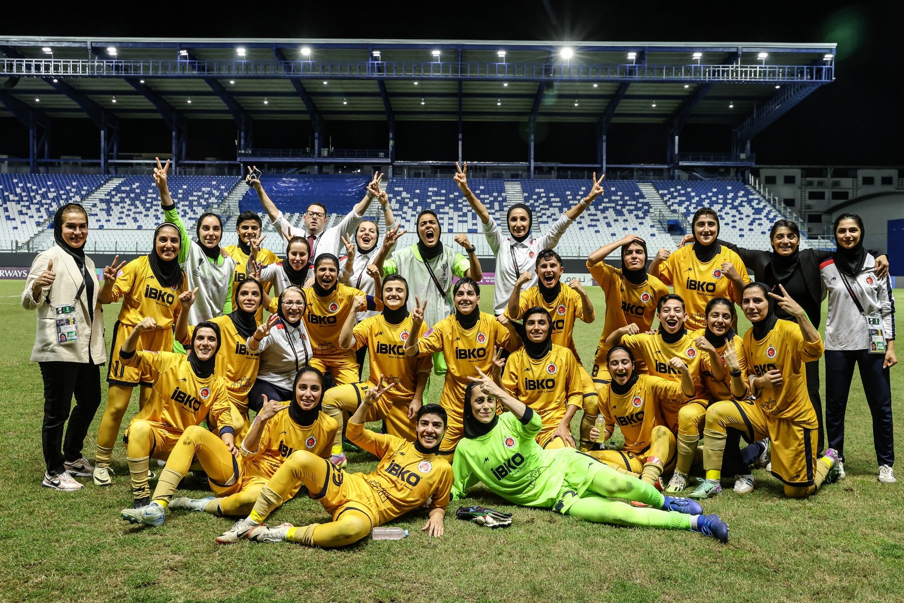 Bam Khatoon FC players and staff celebrating together on the pitch